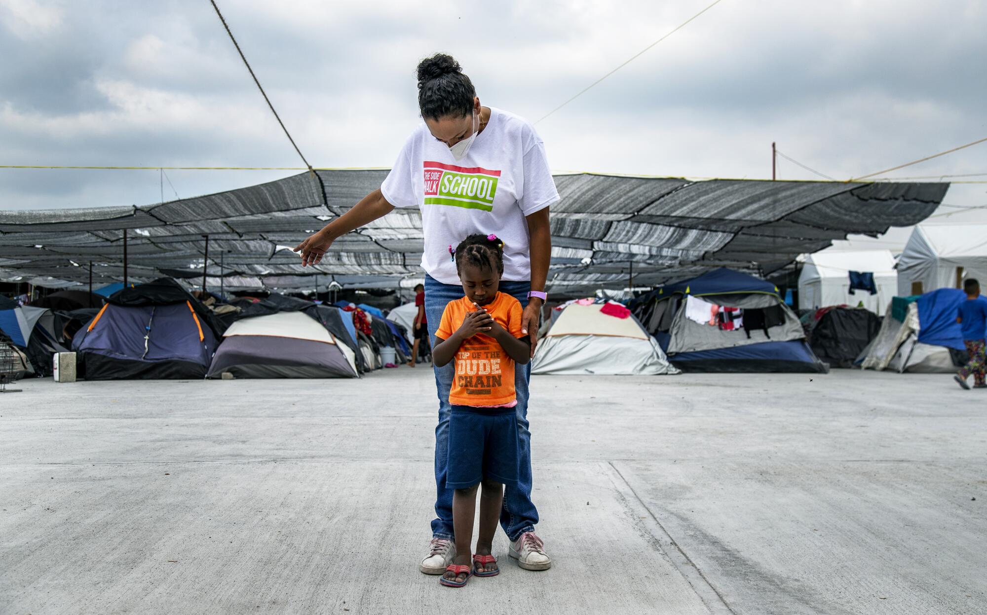 A young Haitian migrant leans on Black Mexican-American border activist Felicia Rangel-Samponaro 