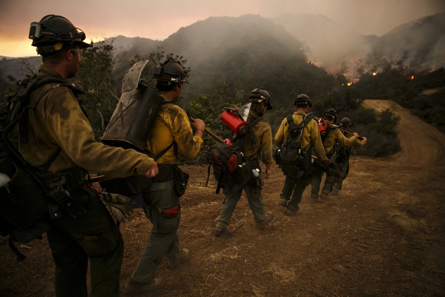 Firefighters march into El Capitan Canyon to conduct a burn-out operation.