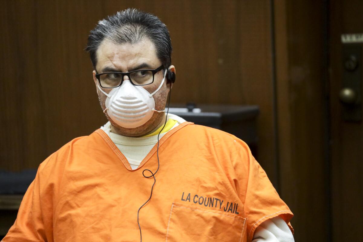 A person in a Los Angeles County Jail uniform, mask and glasses.