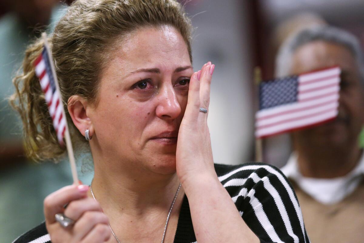 New American citizen Sabaheta Sinanovic from Montenegro wipes a tear after taking the oath of citizenship at a naturalization ceremony in New York City. More than 7,800 new citizens will be naturalized at more than 100 ceremonies this week.