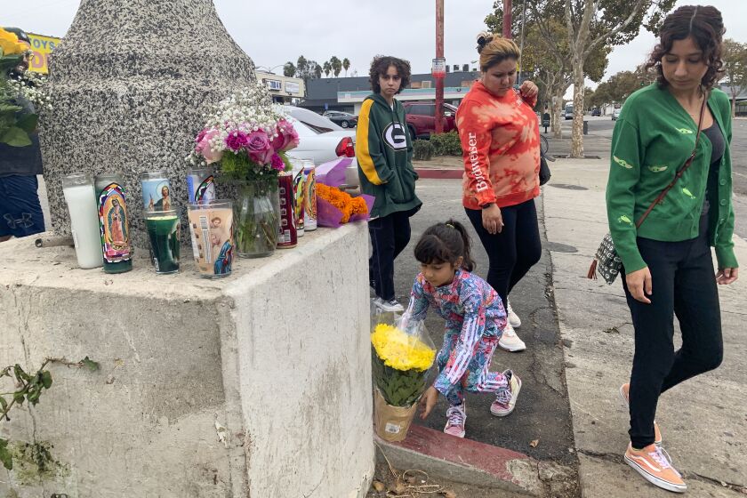 Pomona, CA - October 15: Garbanzo family who regular customers of taco stand bring flower for makeshift memorial at the scene of last Friday night crash in which a motorist plowed into street taco vendor killing one and injuring 12 at 1600 block of Holt Avenue on Saturday, Oct. 15, 2022 in Pomona, CA. (Irfan Khan / Los Angeles Times)