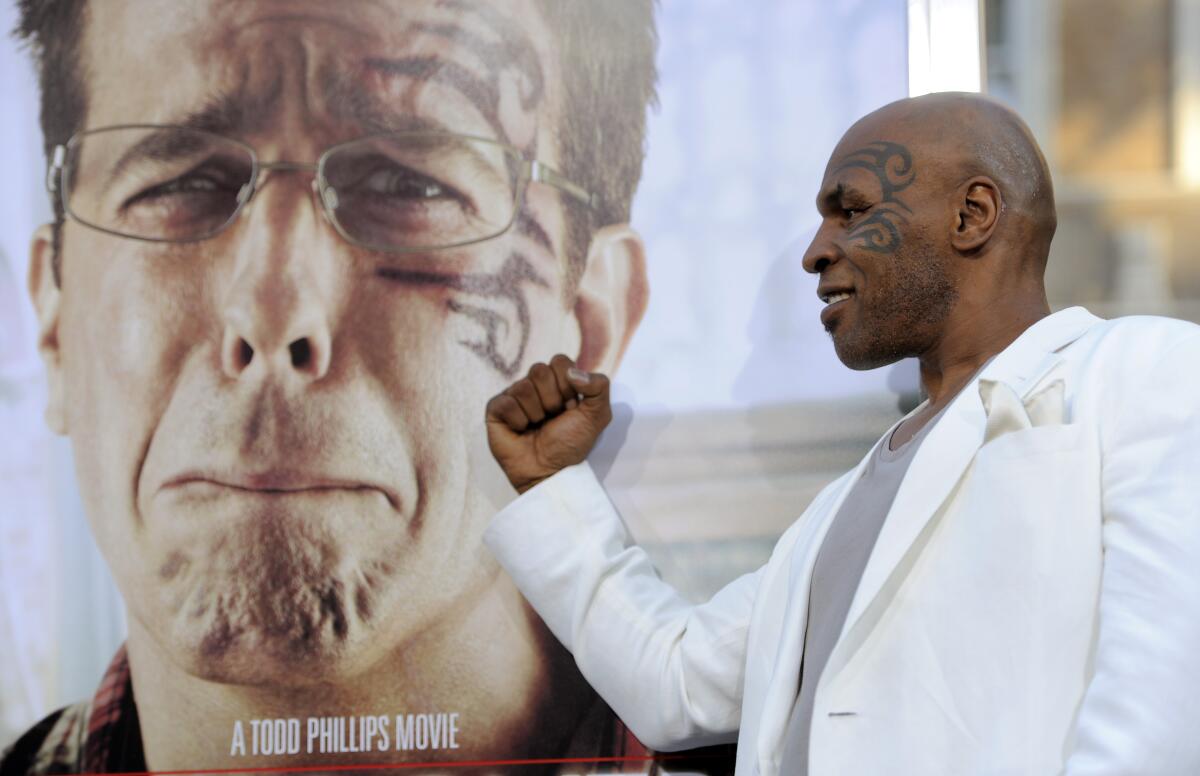 Mike Tyson, a cast member in "The Hangover Part II," poses alongside a poster for the film.
