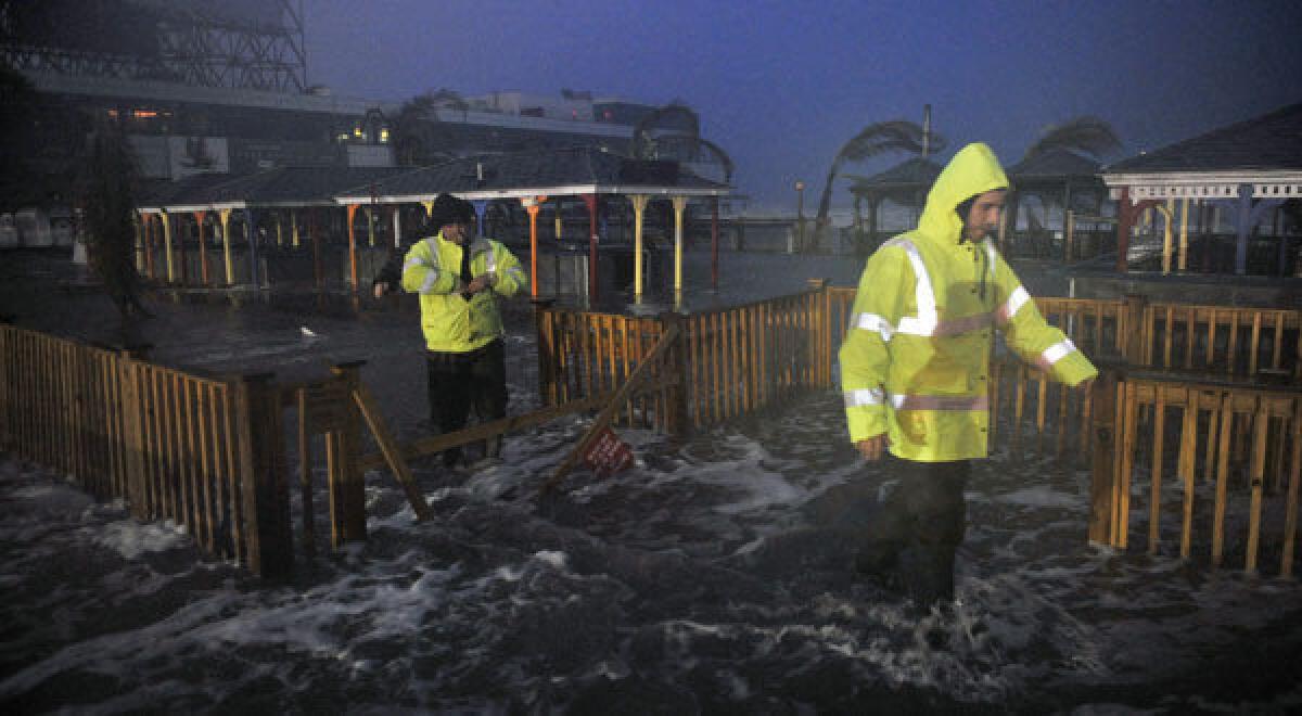 People walk through water on the beach near the time of high tide as Hurricane Sandy approaches in Atlantic City, N.J.