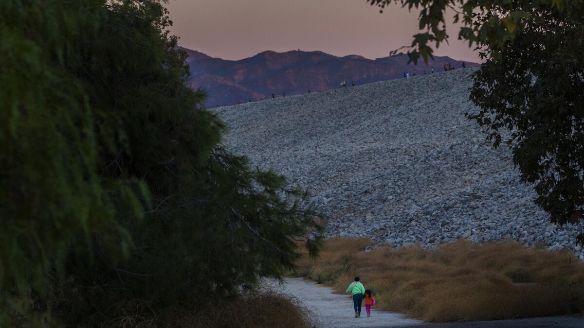 LAKE VIEW TERRACE, CA - SEPTEMBER 27, 2017: Pedestrians walks along one of the circular paths below the Hansen Dam at dusk on September 27, 2017 in Lake View Terrace, California.(Gina Ferazzi / Los Angeles Times)