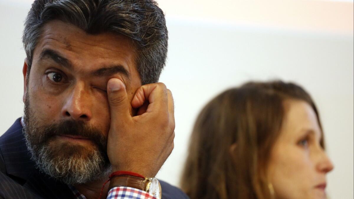 Francisco "Franky" Carrillo, Jr., who was wrongfully imprisoned for 20 years, seated next to his wife Efty Sharony, wipes a tear from his eye on August 4, 2016.