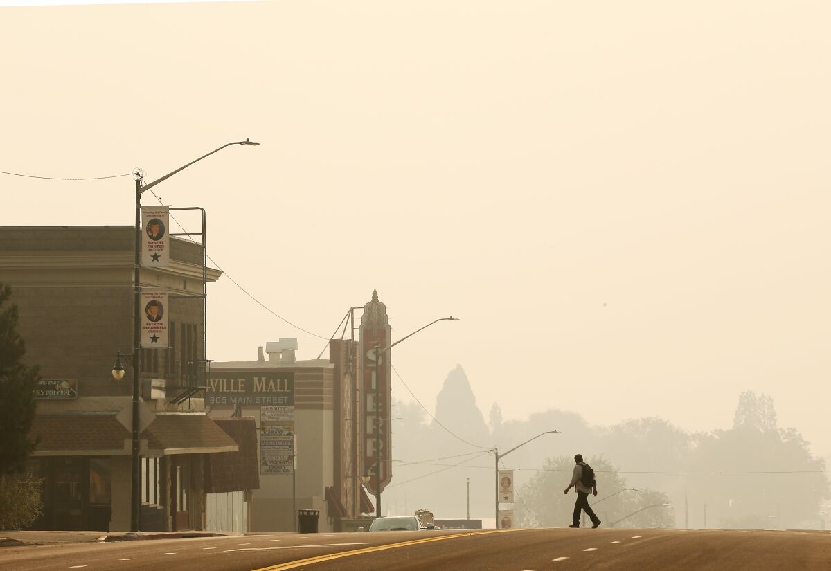 Smoke reduces buildings and trees to silhouettes.
