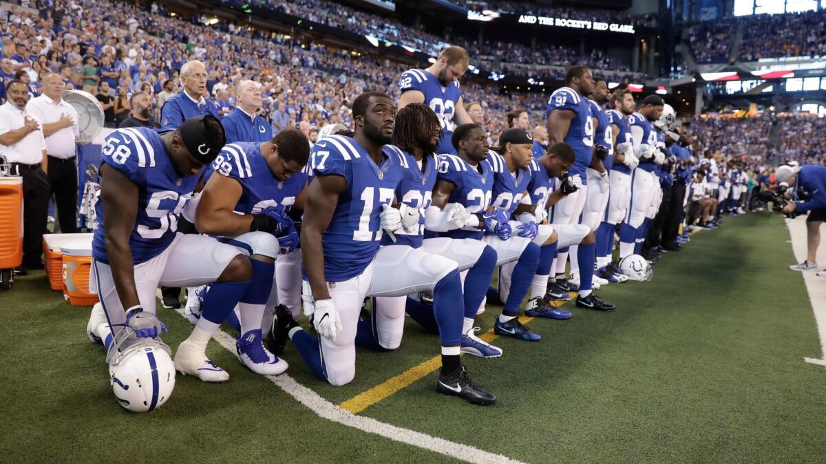 Members of the Indianapolis Colts take a knee during the Nation Anthem before an NFL football game against the Cleveland Browns in Indianapolis on Sept. 24.