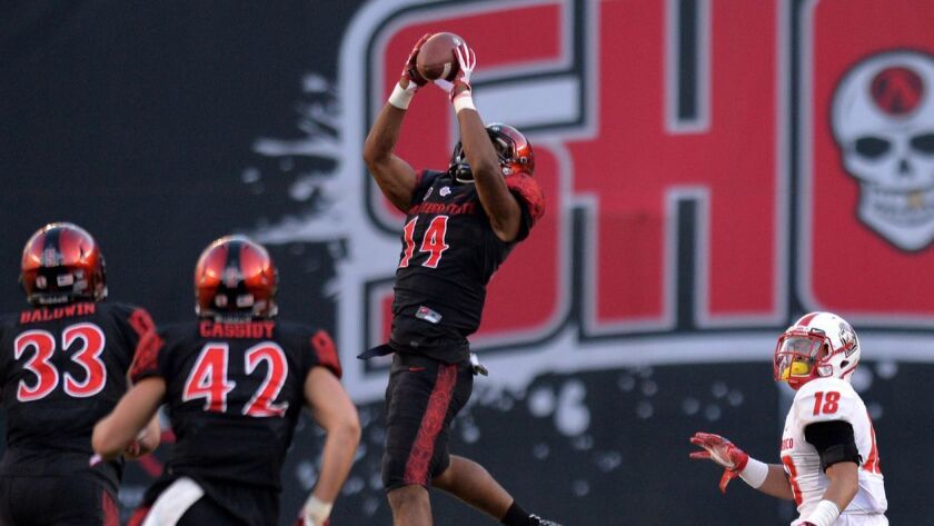 San Diego State safety Tariq Thompson (14) intercepts a pass during a game last season against New Mexico. Thompson led the Aztecs with five interceptions on the year..