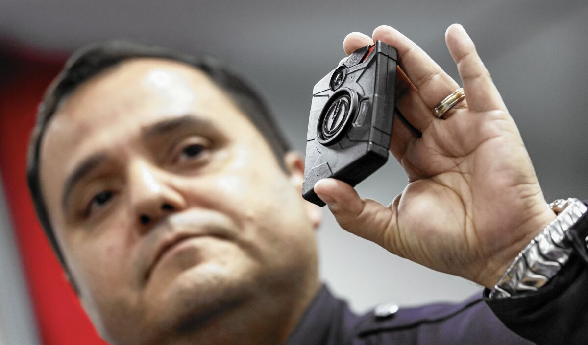 Sgt. Daniel Gomez displays a body camera during a public meeting in January hosted by the Los Angeles Police Commission.
