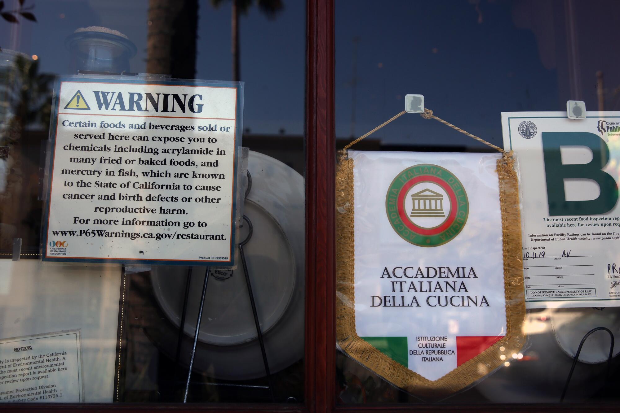 A Proposition 65 sign is prominently displayed on the window of an Il Fornaio Italian restaurant.