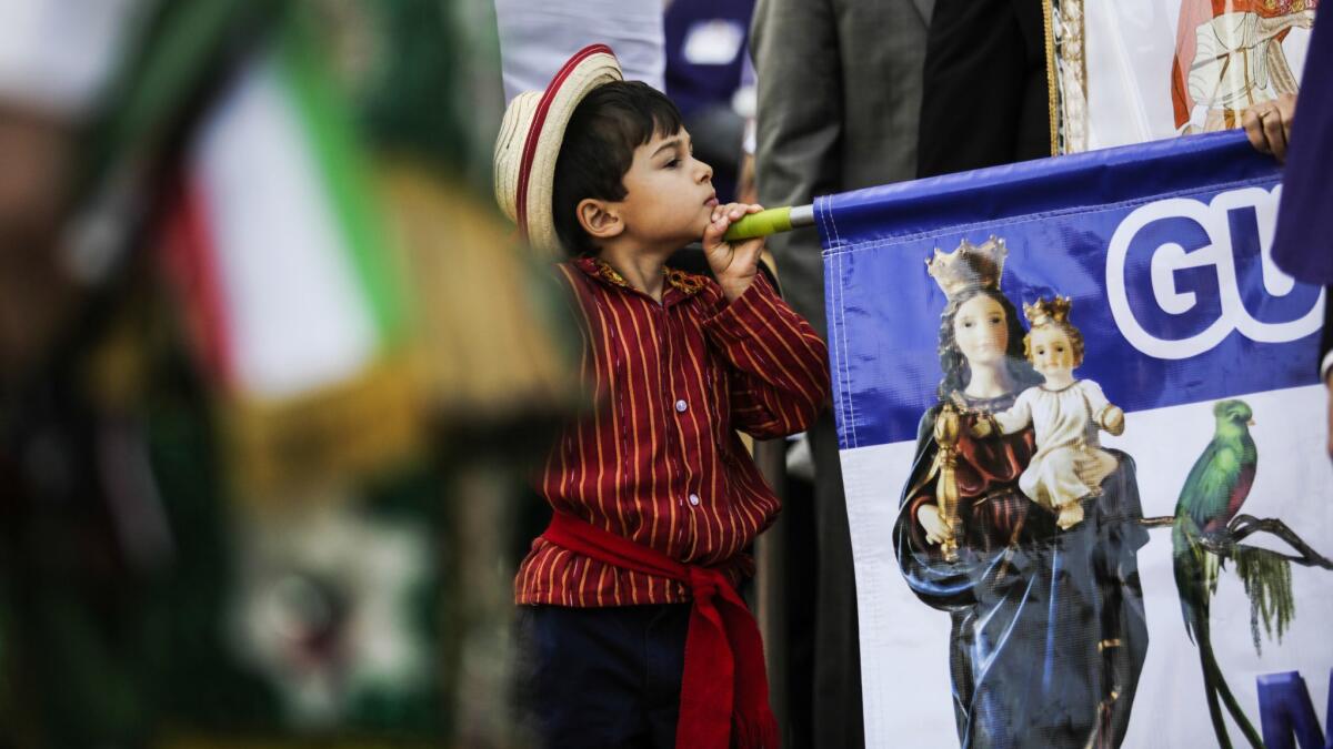 Jonah Oliviero Trabanino, 5, plays with a banner that represents the Virgin of Guatemala.