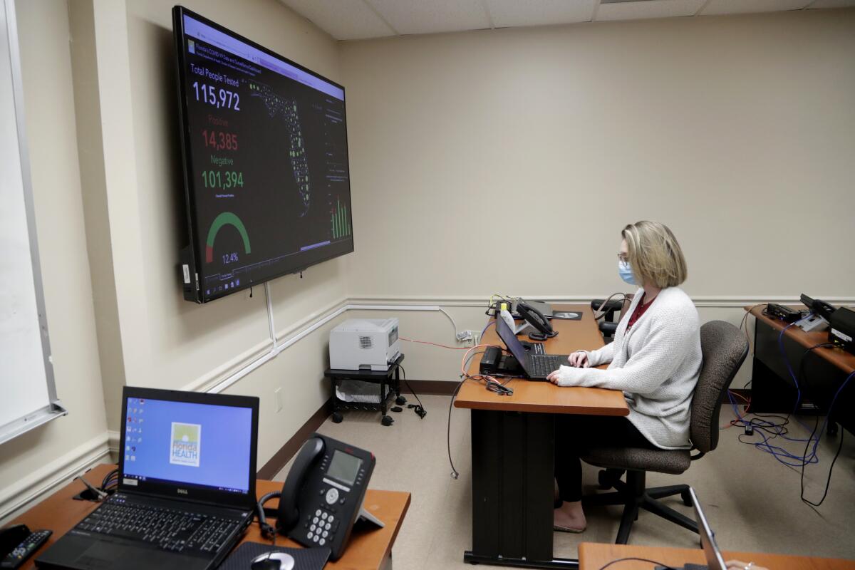 Meghan Peck works at a Florida Department of Health facility in Doral to trace the contacts of a coronavirus patient. In state after state, local health departments charged with doing the detective work of running down the contacts of those who test positive for the virus are well short of hiring enough people to do the job.