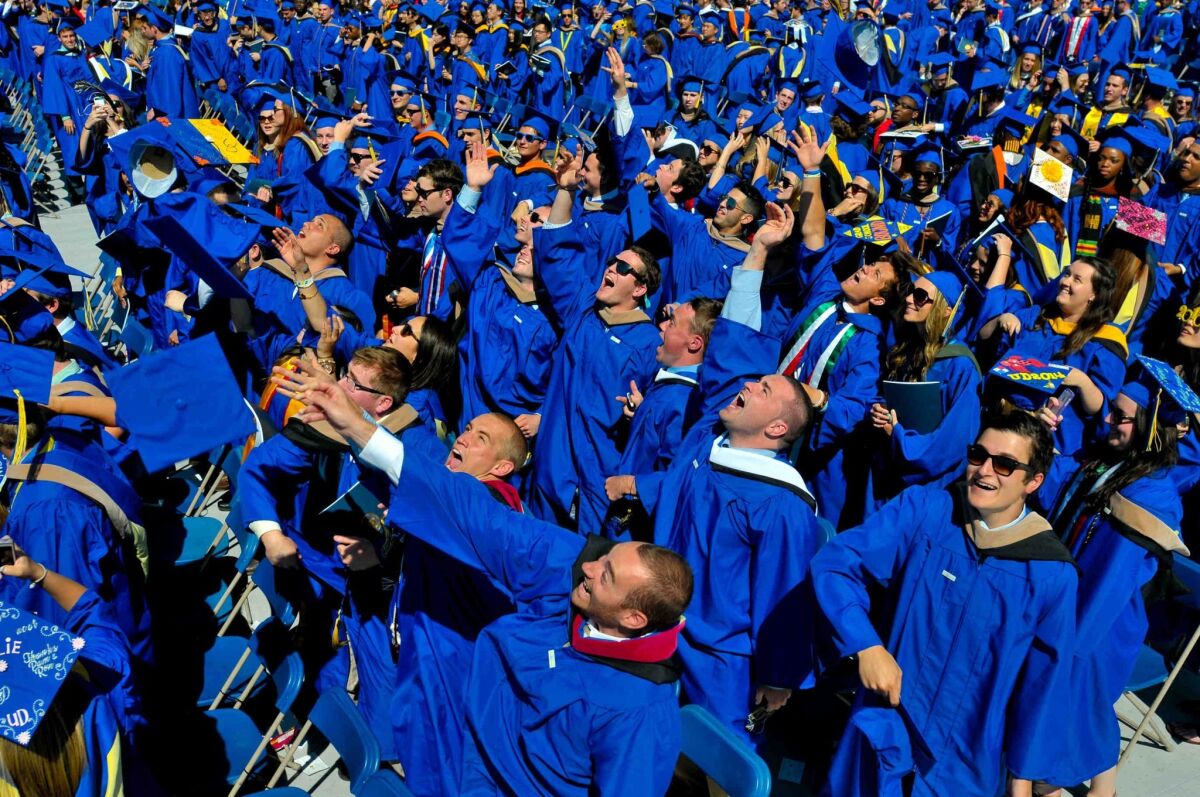 Graduates throw their caps at the University of Delaware's commencement ceremony as the future awaits; more than half of millennials in a study say they live paycheck to paycheck.