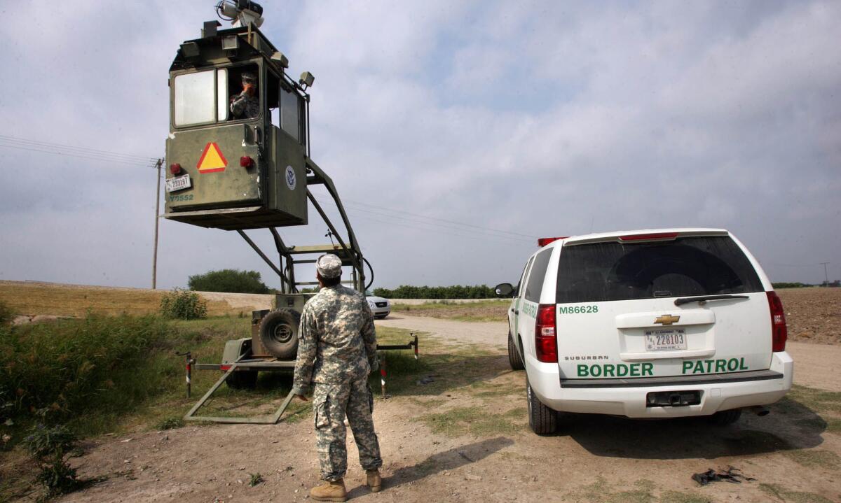 Un miembro de la Guardia Nacional habla con un compañero en una cabina de la Patrulla Fronteriza en Hidalgo, Texas.