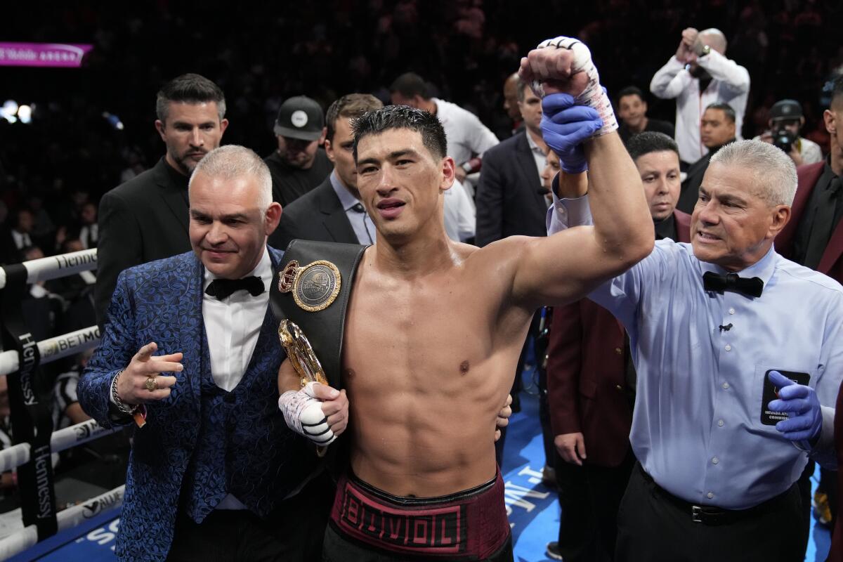 Dmitry Bivol holds up a fist after defeating Canelo Álvarez.