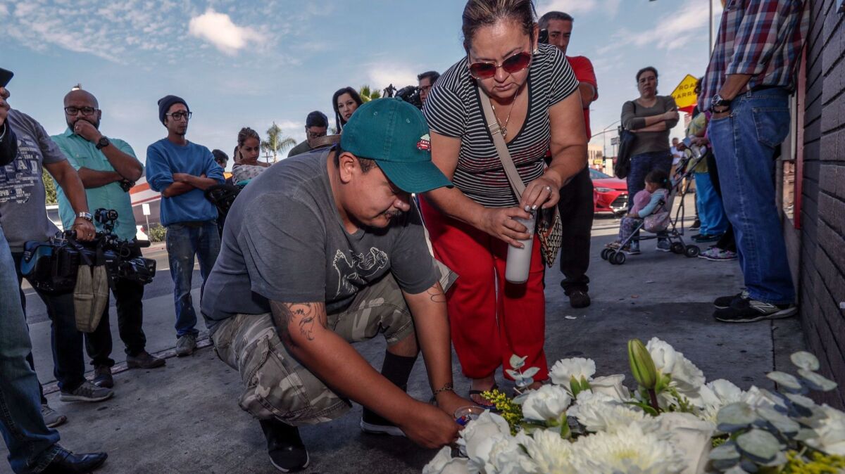 Luis Hernandez, left, and Araceli Cortez place flowers at a memorial for Hernandez s younger siblings, who were killed when an L.A. County sheriff s vehicle careened onto a sidewalk after a crash in Boyle Heights.