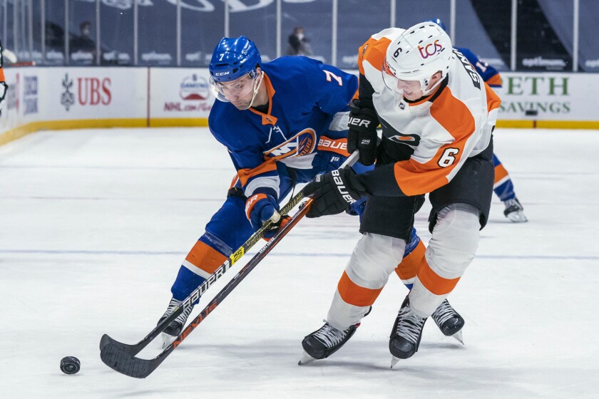New York Islanders right wing Jordan Eberle, left, and Philadelphia Flyers defenseman Travis Sanheim vie for the puck during the second period of an NHL hockey game Saturday, April 3, 2021, at Nassau Coliseum in Uniondale, N.Y. (AP Photo/Corey Sipkin).