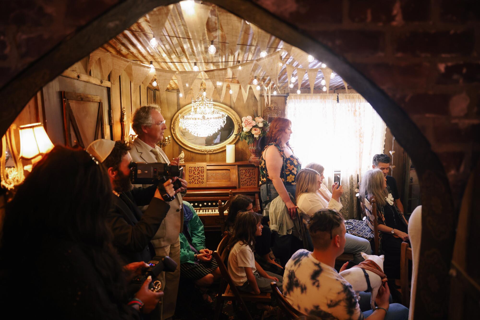 A crowd watches a wedding ceremony in a chapel