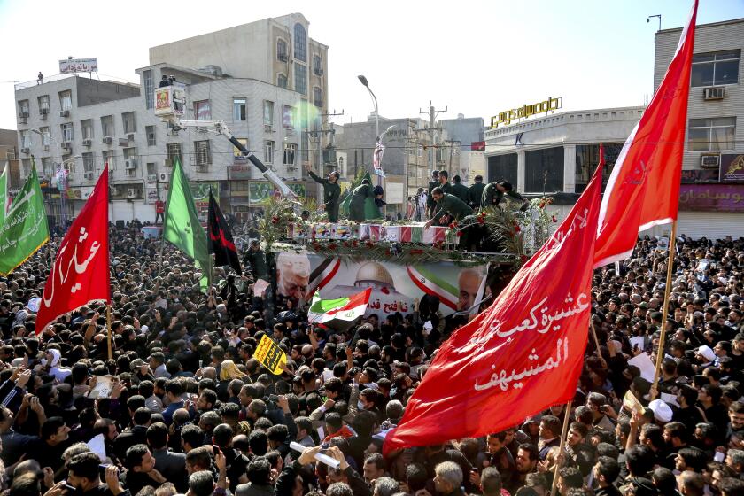 In this photo provided by The Iranian Students News Agency, ISNA, flag draped coffins of Gen. Qassem Soleimani and his comrades who were killed in Iraq in a U.S. drone strike, carried on a truck surrounded by mourners during their funeral in southwestern city of Ahvaz, Iran, Sunday, Jan. 5, 2020. The body of Soleimani arrived Sunday in Iran to throngs of mourners, as U.S. President Donald Trump threatened to bomb 52 sites in the Islamic Republic if Tehran retaliates by attacking Americans. (Alireza Mohammadi/ISNA via AP)