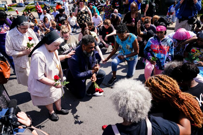 People pray outside the scene of a shooting at a supermarket in Buffalo, N.Y., Sunday, May 15, 2022. (AP Photo/Matt Rourke)