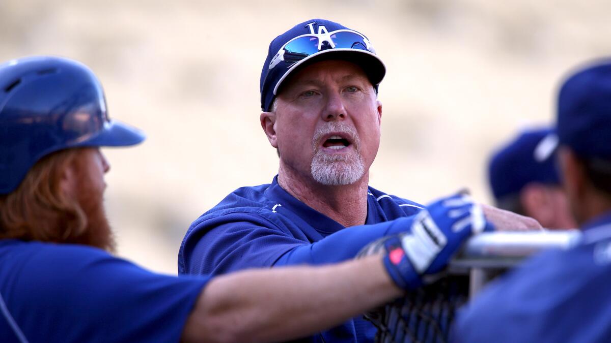 Hitting coach Mark McGwire talks with Justin Turner as the Dodgers take batting practice before a game against the San Diego Padres on Oct. 2, 2015.