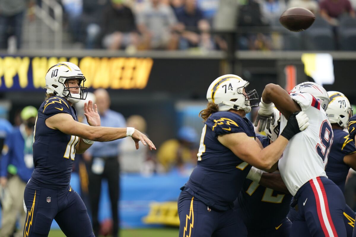 Los Angeles Chargers quarterback Justin Herbert, left, throws during the first half of an NFL football game against the New England Patriots Sunday, Oct. 31, 2021, in Inglewood, Calif. (AP Photo/Jae C. Hong )