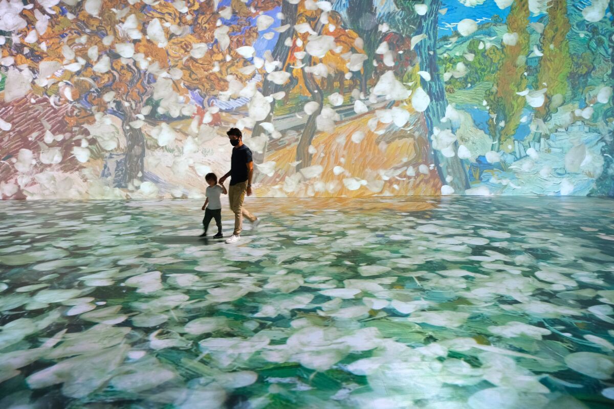 Visitors walk through the "Beyond Van Gogh" exhibition.