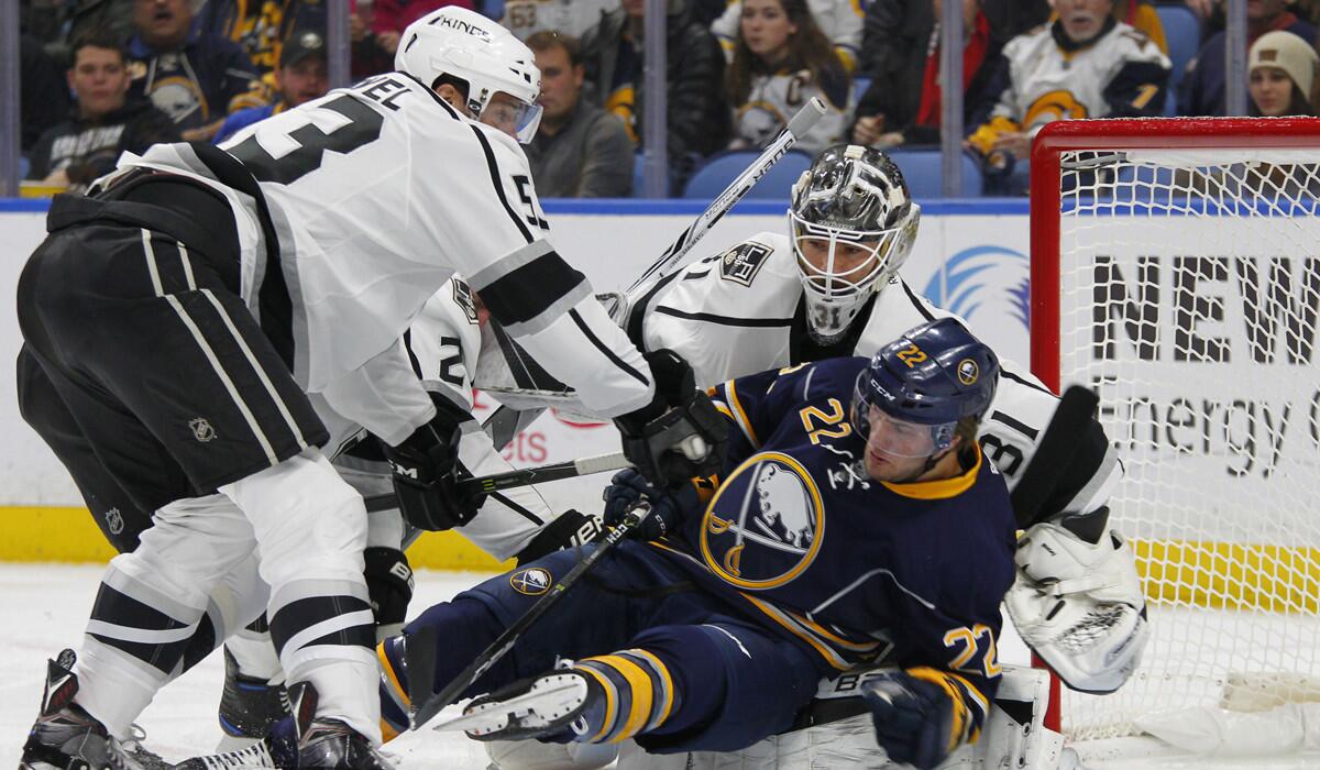 Buffalo Sabres forward Johan Larsson is knocked into Kings goalie Peter Budaj by defenseman Kevin Gravel (53) during the first period.