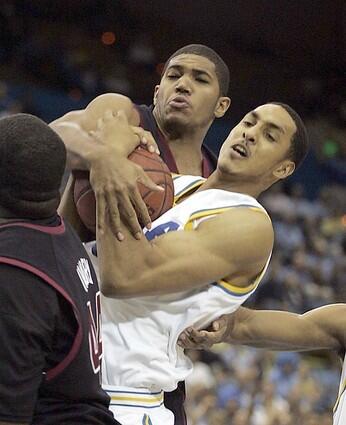THEYRE ALL TIED UP: UCLAs Ryan Hollins, right, battles Temples Dustin Salisbery for a loose ball during the first half.