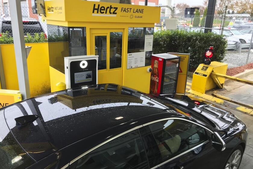 In this Friday, Dec. 7, 2018, photo, a rental car approaches a biometric scanning machine at the exit of the Hertz facility at Hartsfield-Jackson Atlanta International Airport, in Atlanta. In a first for the rental car industry, Hertz is teaming up with Clear, the maker of biometric screening kiosks found at many airports and stadiums. Hertz says the partnership will slash the time it takes to pick up a rental car. (AP Photo/Jeff Martin)