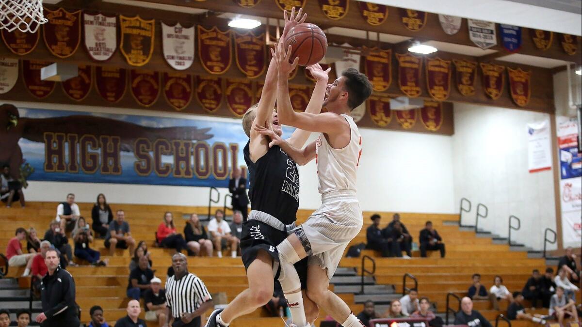Huntington Beach High's Nick Saccacio, right, gets tangled up with Pomona Diamond Ranch defender Garrett Parker during a fastbreak in the Jim Harris Classic at Ocean View High on Tuesday.