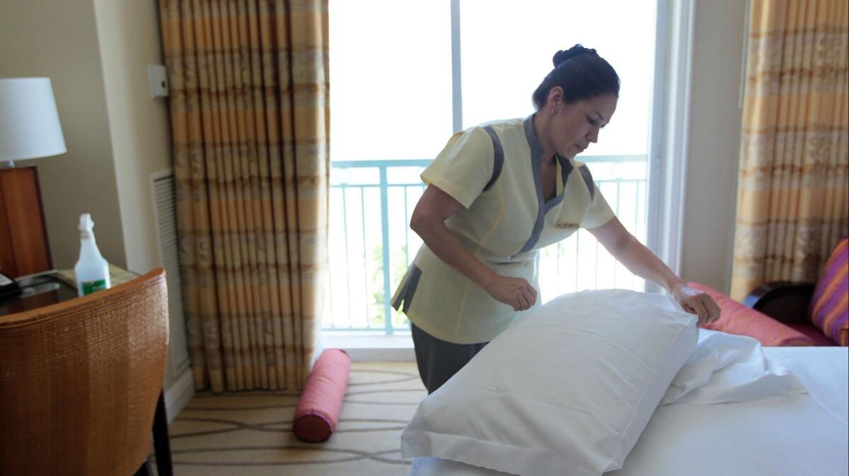 A housekeeper at a hotel in Miami prepares a room for a new occupant in 2010. A coalition of hotel operators has announced plans to equip hotel workers with "panic buttons."