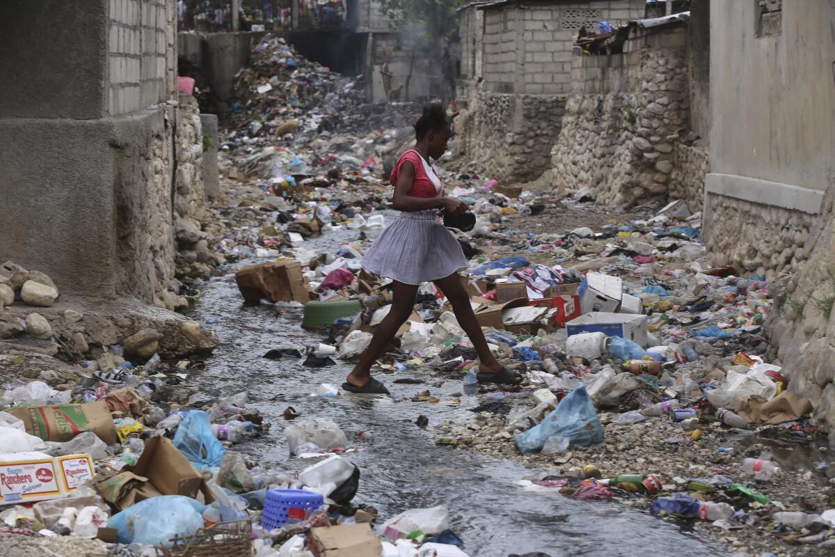 Una niña camina por una calle llena de basura en Puerto Príncipe, Haití, 