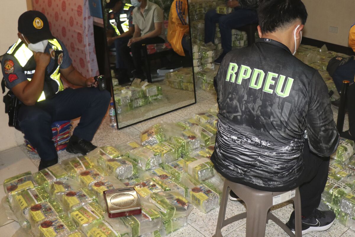 En esta imagen proporcionada por la Policía Regional de Cordillera, policías revisan bolsas de té con supuesta metanfetamina durante una redada en una casa en la ciudad de Baguio, en el norte de Filipinas, el miércoles 29 de marzo de 2023. (Policía Regional de Cordillera, via AP)