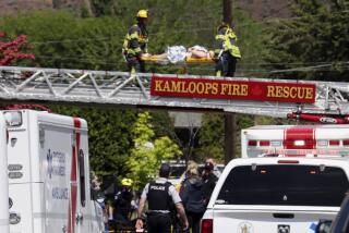 An injured person is carried across a fire truck ladder from a rooftop following the crash of an aerobatic jet in Kamloops, Canada, on Sunday.