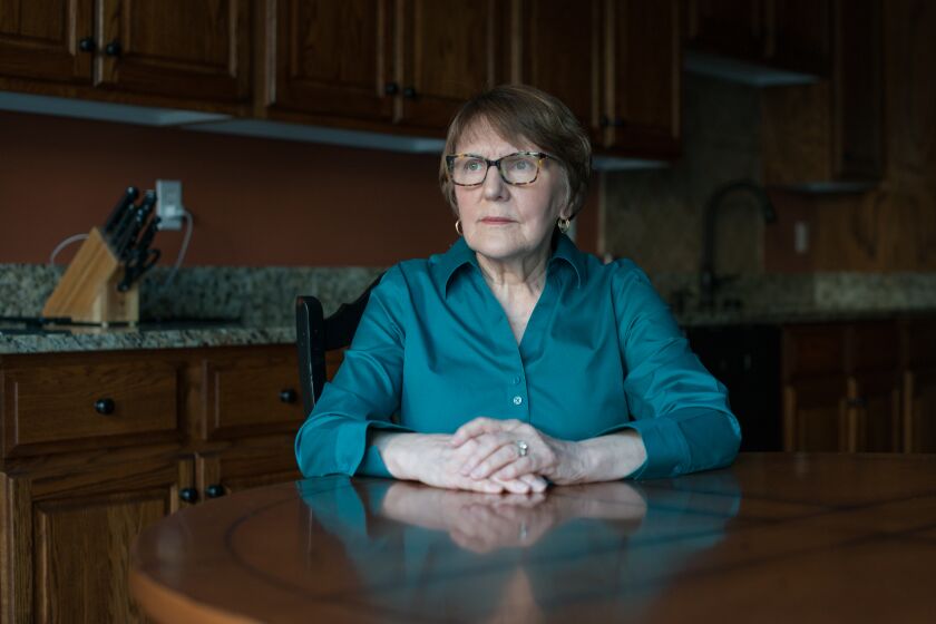 A senior woman who was diagnosed with generalized anxiety disorder is seated at a table at her home.