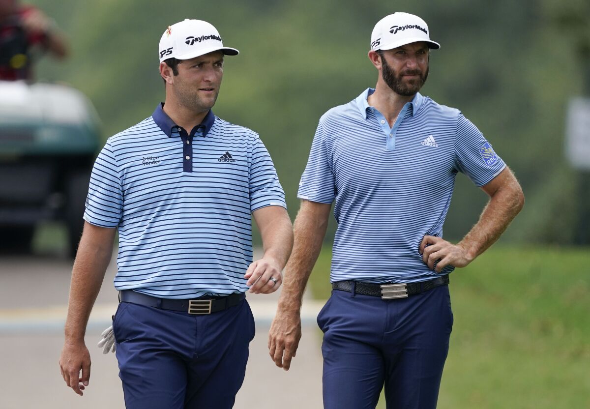 Jon Rahm, left, and Dustin Johnson walk to the tee during the first round of the Tour Championship on Sept. 4, 2020.