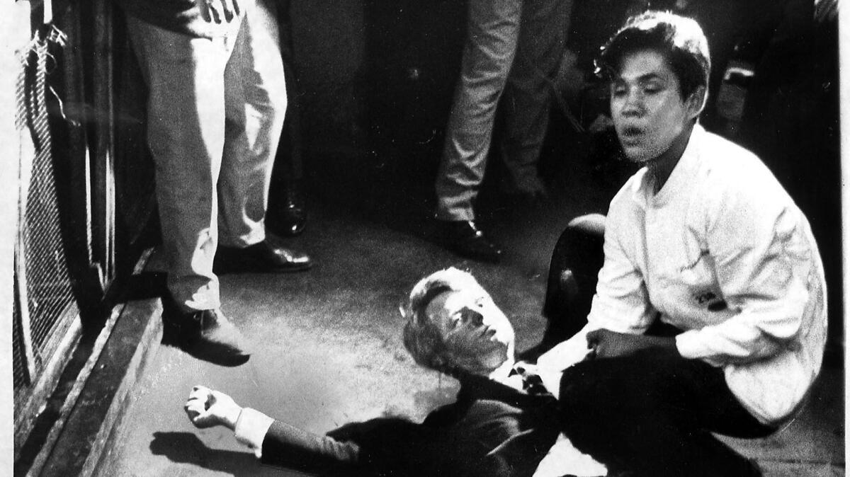 Sen. Robert F. Kennedy lies on the floor of the Ambassador Hotel kitchen cradled by busboy Juan Romero moments after he was shot and mortally wounded in 1968. (Boris Yaro / Los Angeles Times)