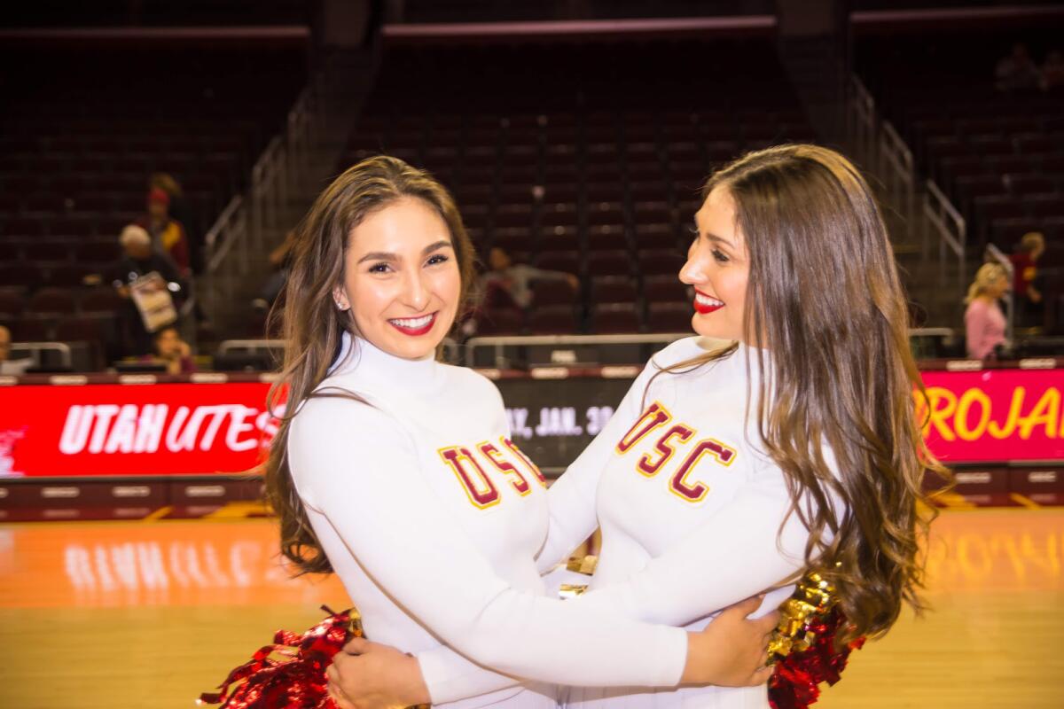 USC Song Girls Bella Robakowski, left, and her sister Adrianna, right, embrace during a Trojans basketball game.