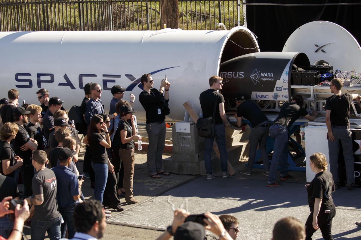 A team loads their magnetic levitation pod during the Hyperloop Pod Competition by SpaceX.