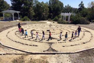 Big Tree Little Preschool owner Rebecca Cook leads a class of 5-year-olds through the new spiral labyrinth at the Palomar Unitarian Universalist Fellowship in Vista.