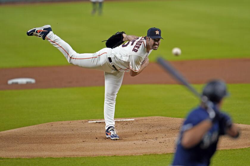 Houston Astros starting pitcher Justin Verlander, left, throws to Seattle Mariners' Evan White.