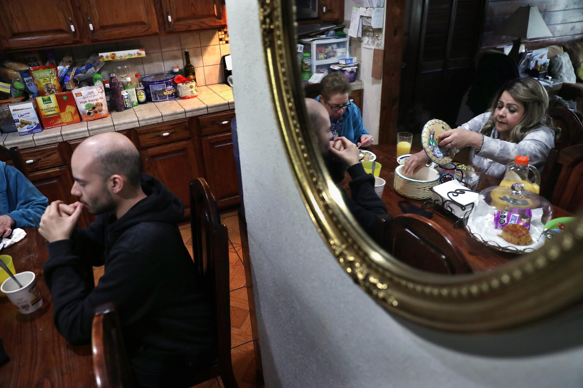  Blanca Lopez, right, eats with her mother Maria Esther Lopez, and son David Muno,  left, at home in Glendale.