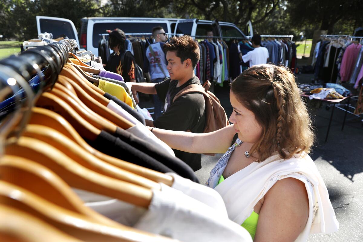 Maria Davila, right, and Ramon Lavares, both 18 and from the San Fernando Valley, shop for vintage streetwear at the Rose Bowl Flea Market last month.