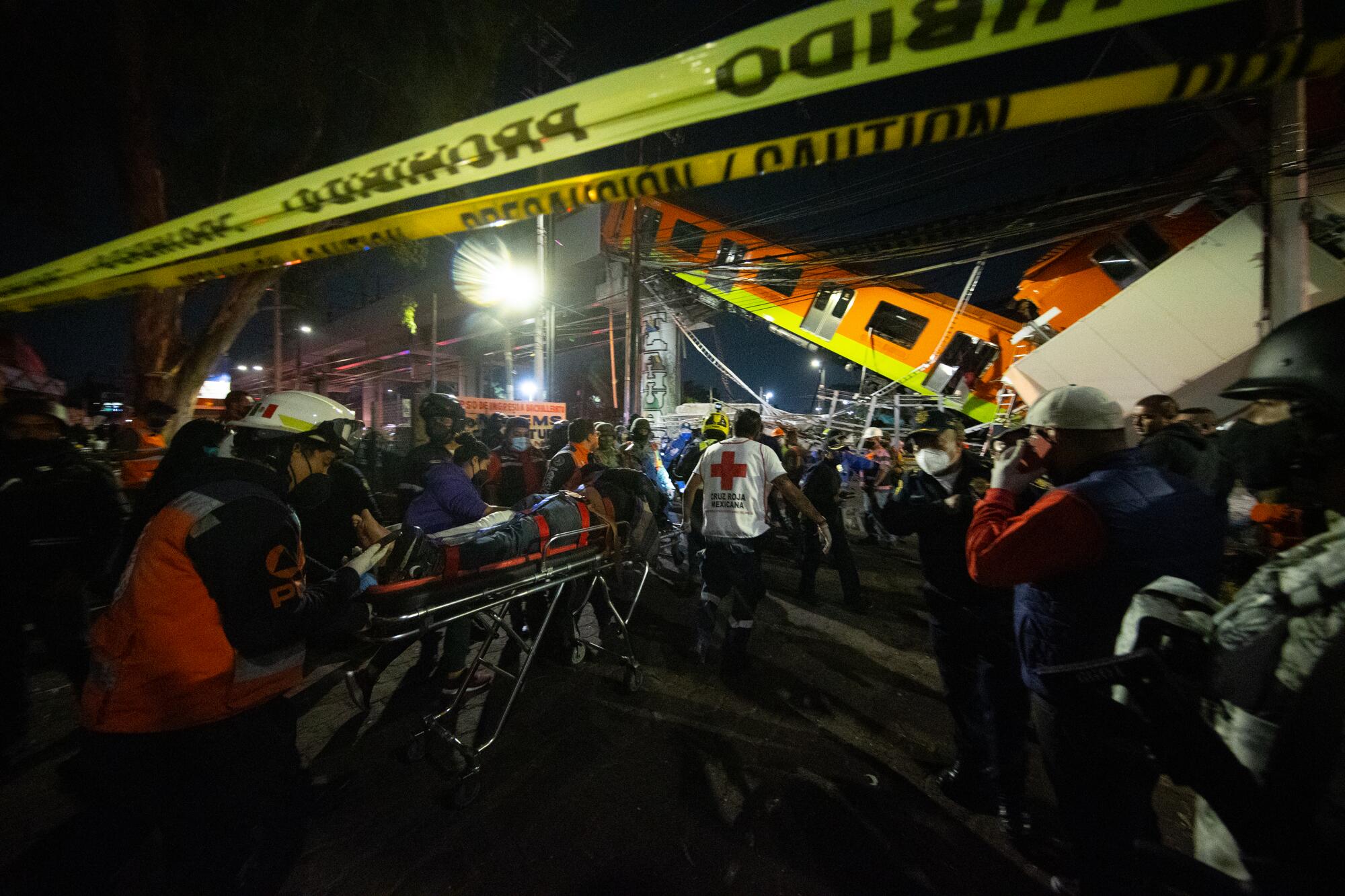 The injured are carried by stretcher away from the scene of a raised subway track that collapsed.