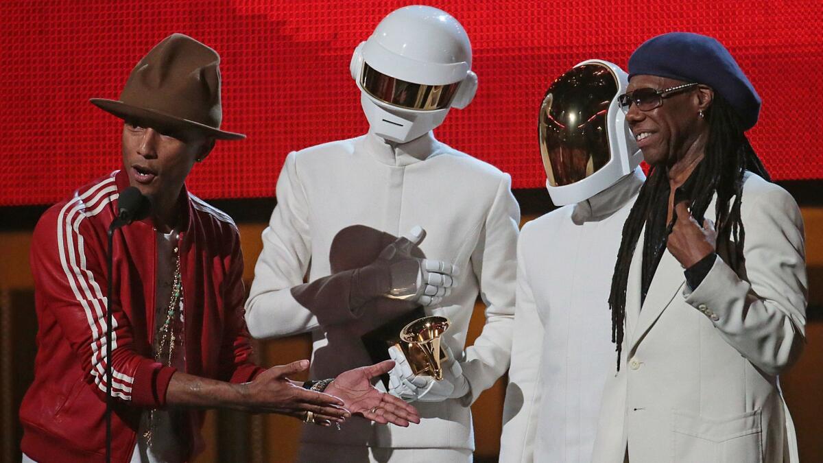 Pharrell Williams, left, with Chic's Nile Rodgers, right, and members of Daft Punk at the Grammy Awards in 2014. Williams will induct Rodgers into the Rock and Roll Hall of Fame on April 7.