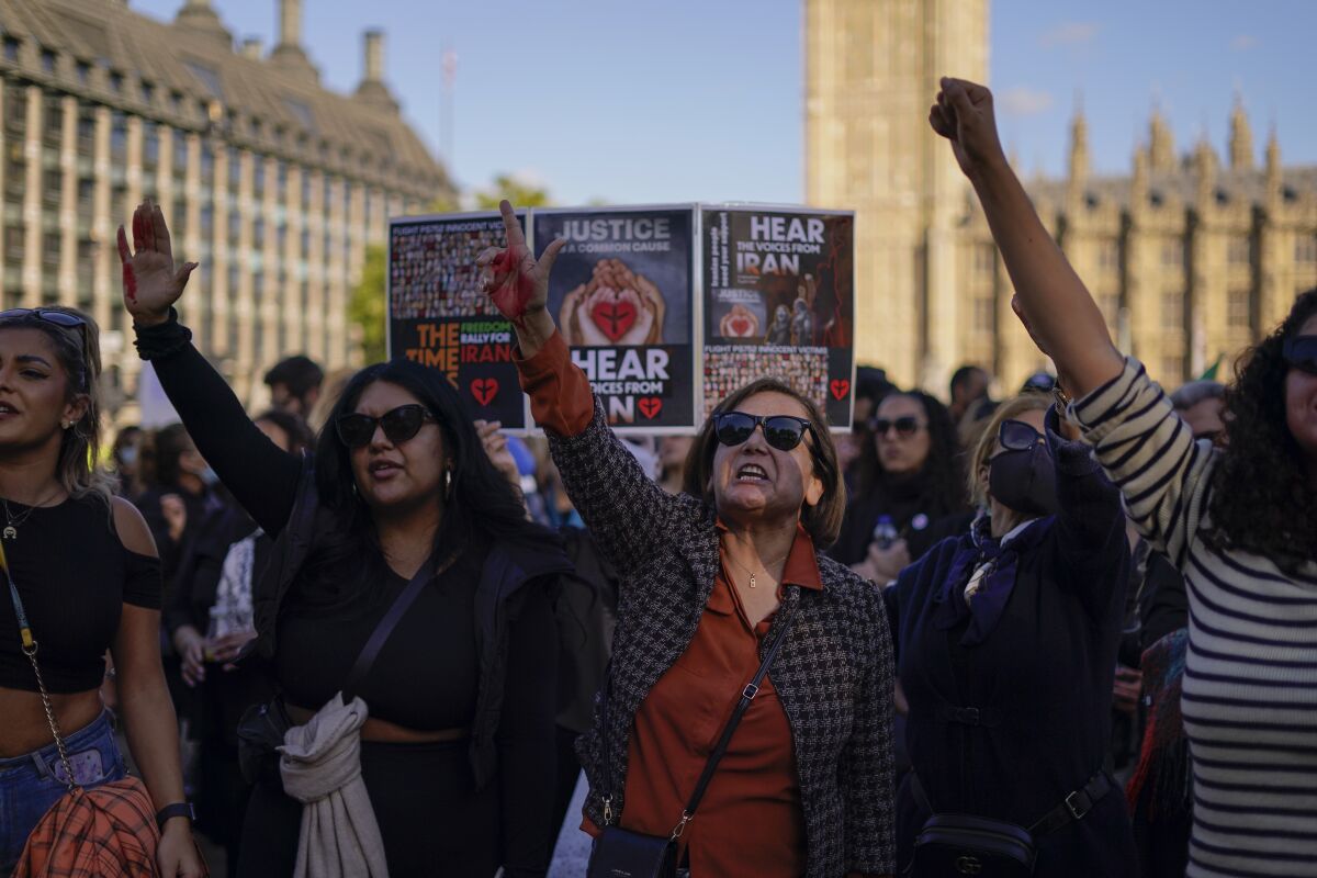 People take part in a protest against Iran's government in Parliament Square, in London, Saturday, Oct. 8, 2022. 