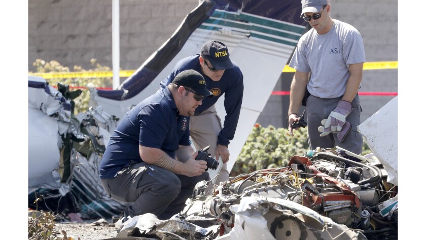 National Transportation Safety Board officials investigate the scene of a plane crash in Santa Ana near South Coast Plaza.