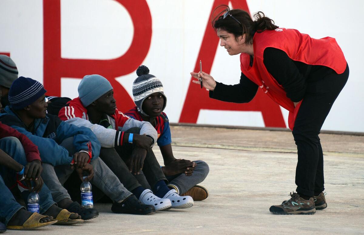 Shipwrecked migrants listen to an Italian Red Cross worker after disembarking from a rescue vessel in the Italian port of Augusta on April 16.