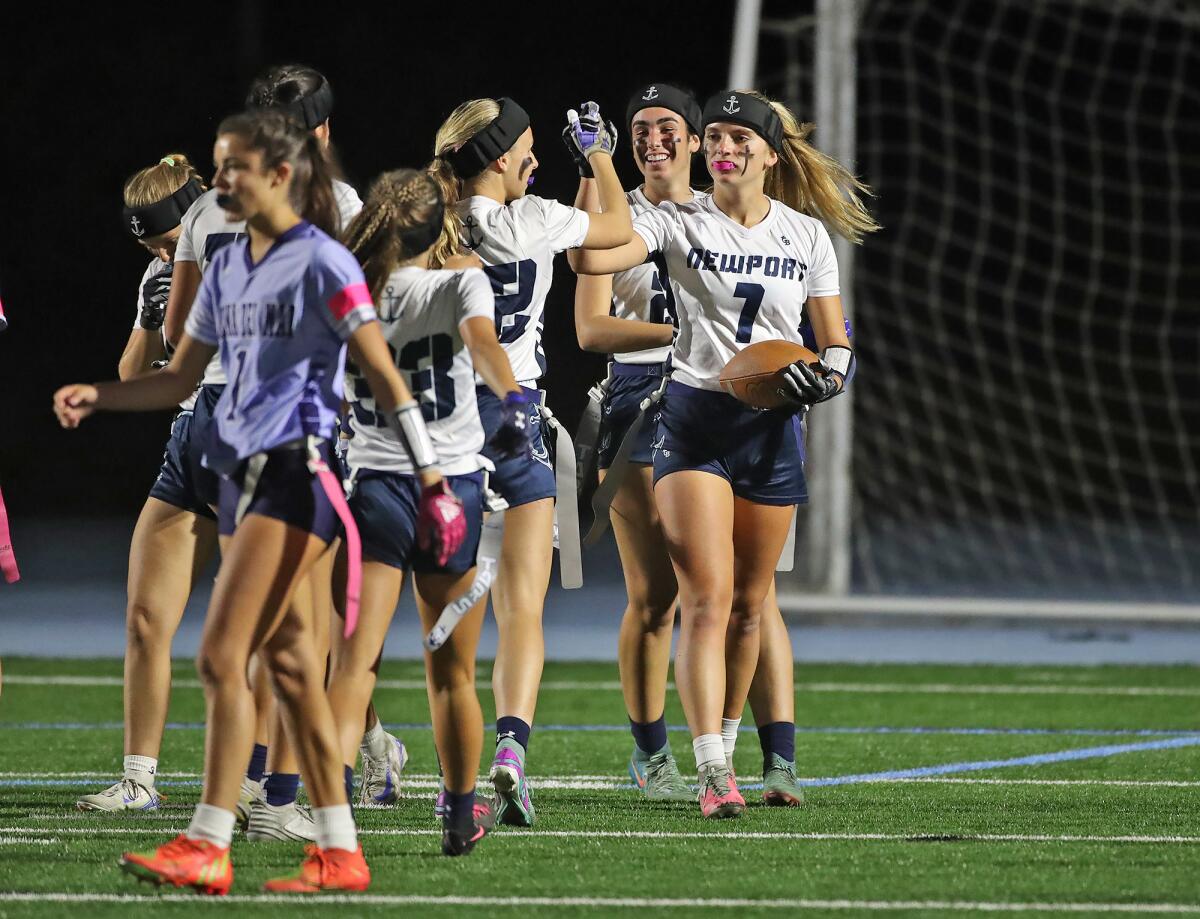 Newport Harbor players celebrate a touchdown by Cooper Dick (1) during the Battle of the Bay girls' flag football game.